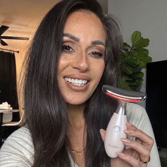 Woman using a red light face wand at home